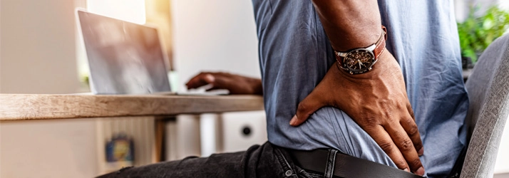 Chiropractic Allen TX Back Pain A person holding their lower back.